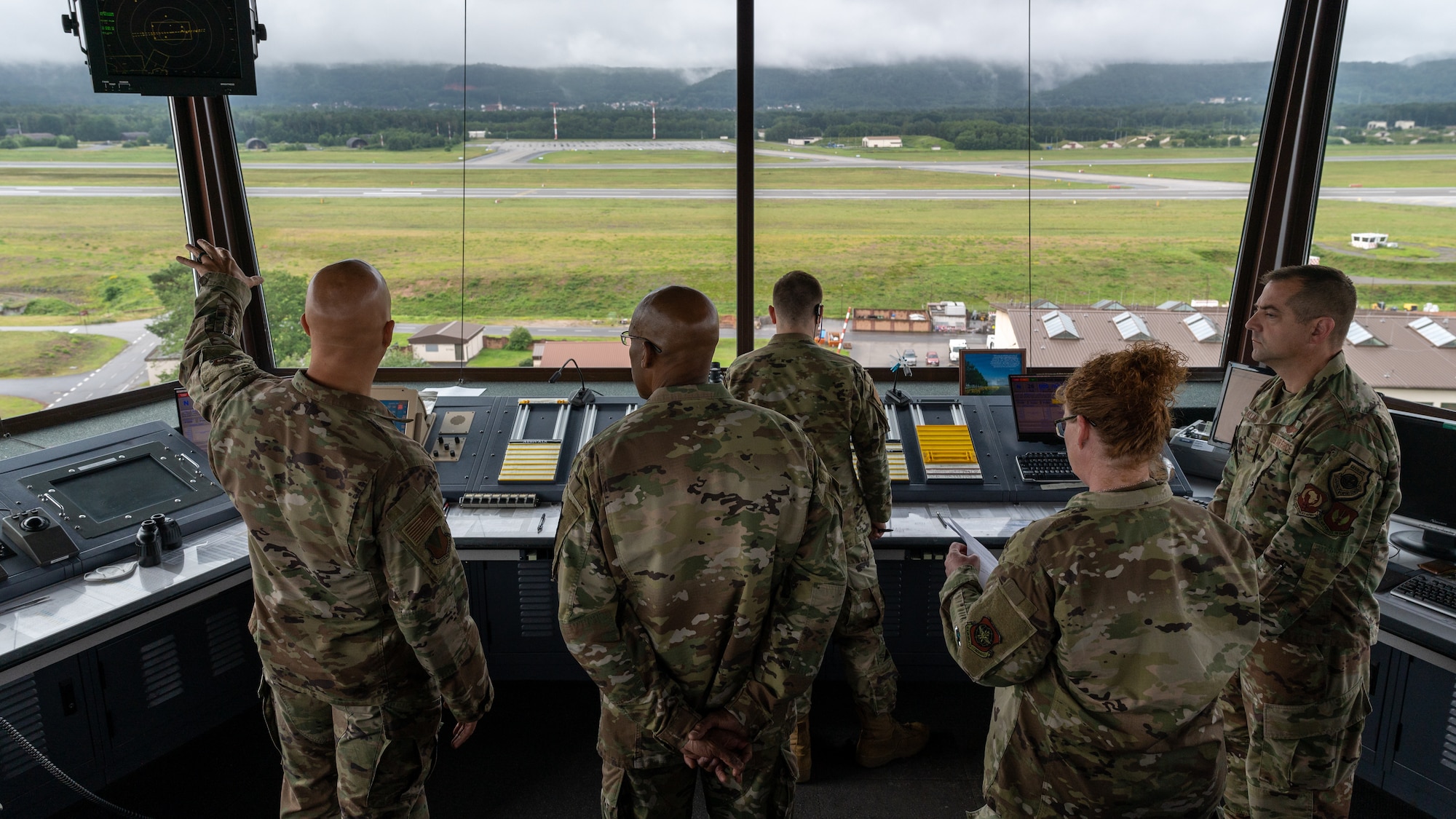 Airmen look at the flightline from the Air Traffic Control Tower