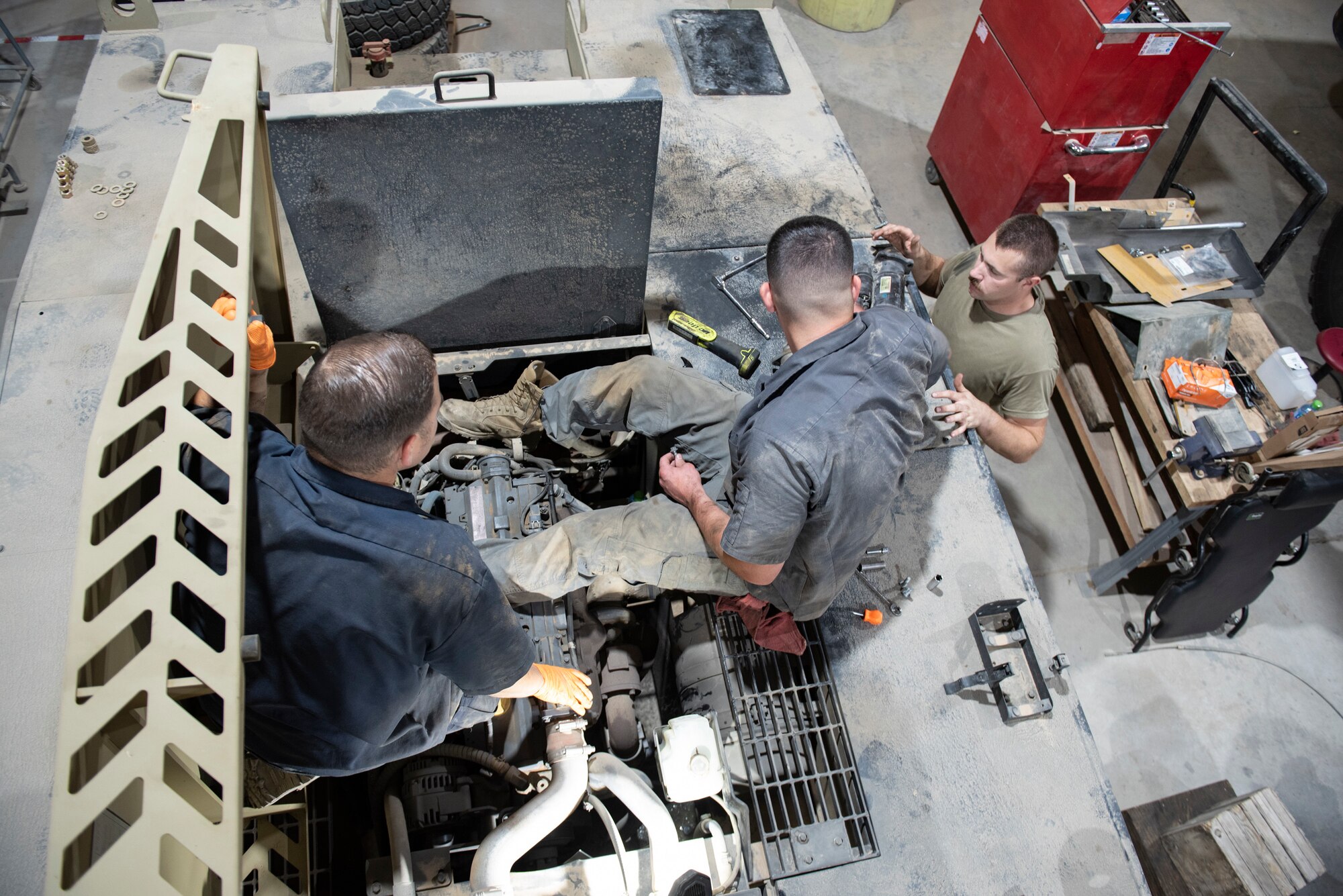 U.S. Air Force Staff Sgt. Douglas Johnson, (left) a vehicle maintainer assigned to the 386th Expeditionary Logistics Readiness Squadron, helps U.S. Air Force Staff Sgt. Brice Thompson, (right) a vehicle maintainer assigned to the 386th Expeditionary Logistics Readiness Squadron, change a starter in a MV-2 toe tractor at Ali Al Salem Air Base, Kuwait, July 8, 2021.