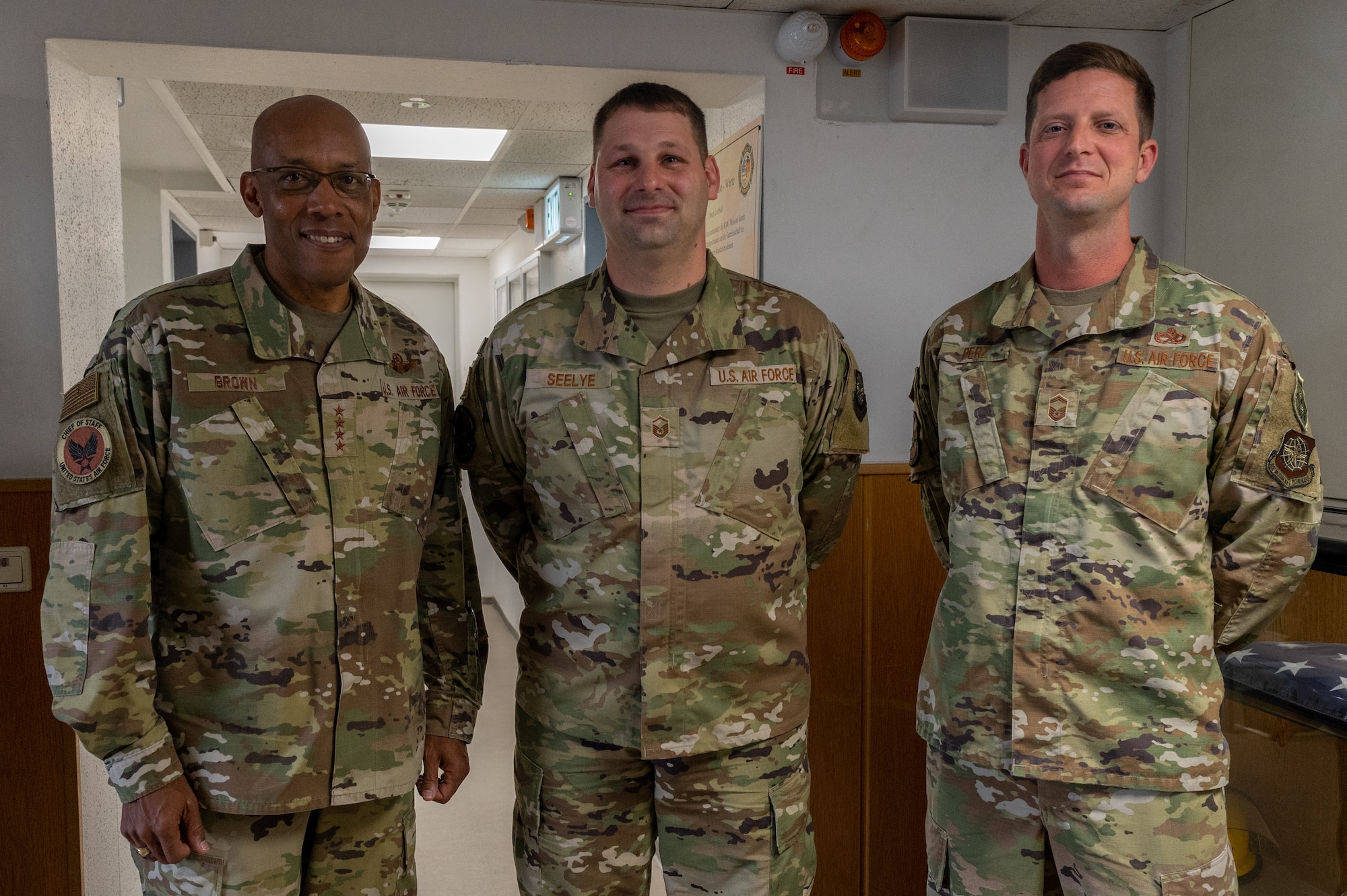 CSAF standing with two Airmen.