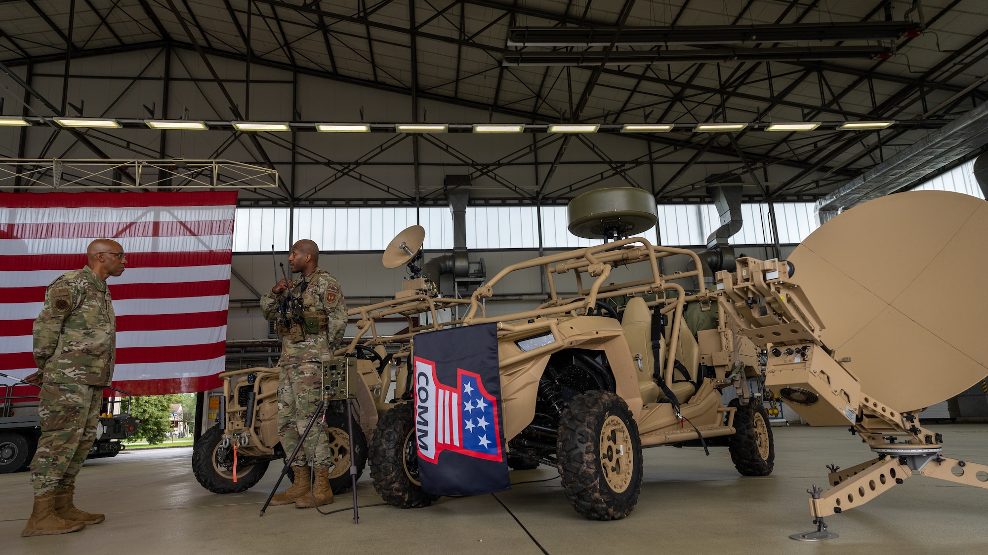 CSAF standing with an Airman next to a communications capability display.