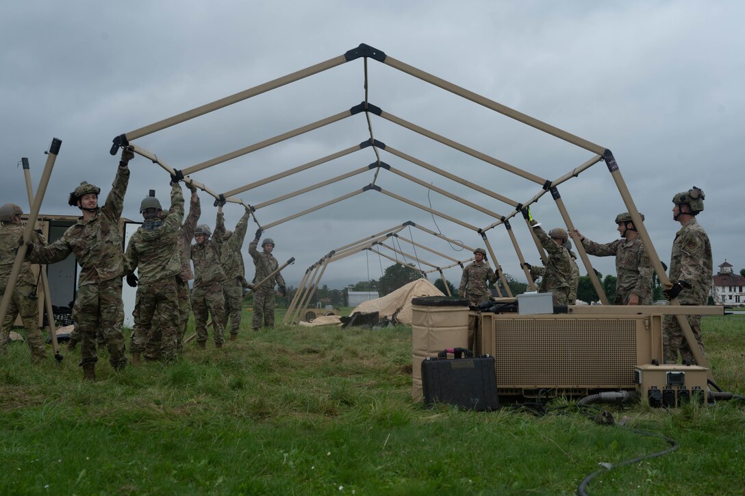 A group of Airmen disassemble a tent.