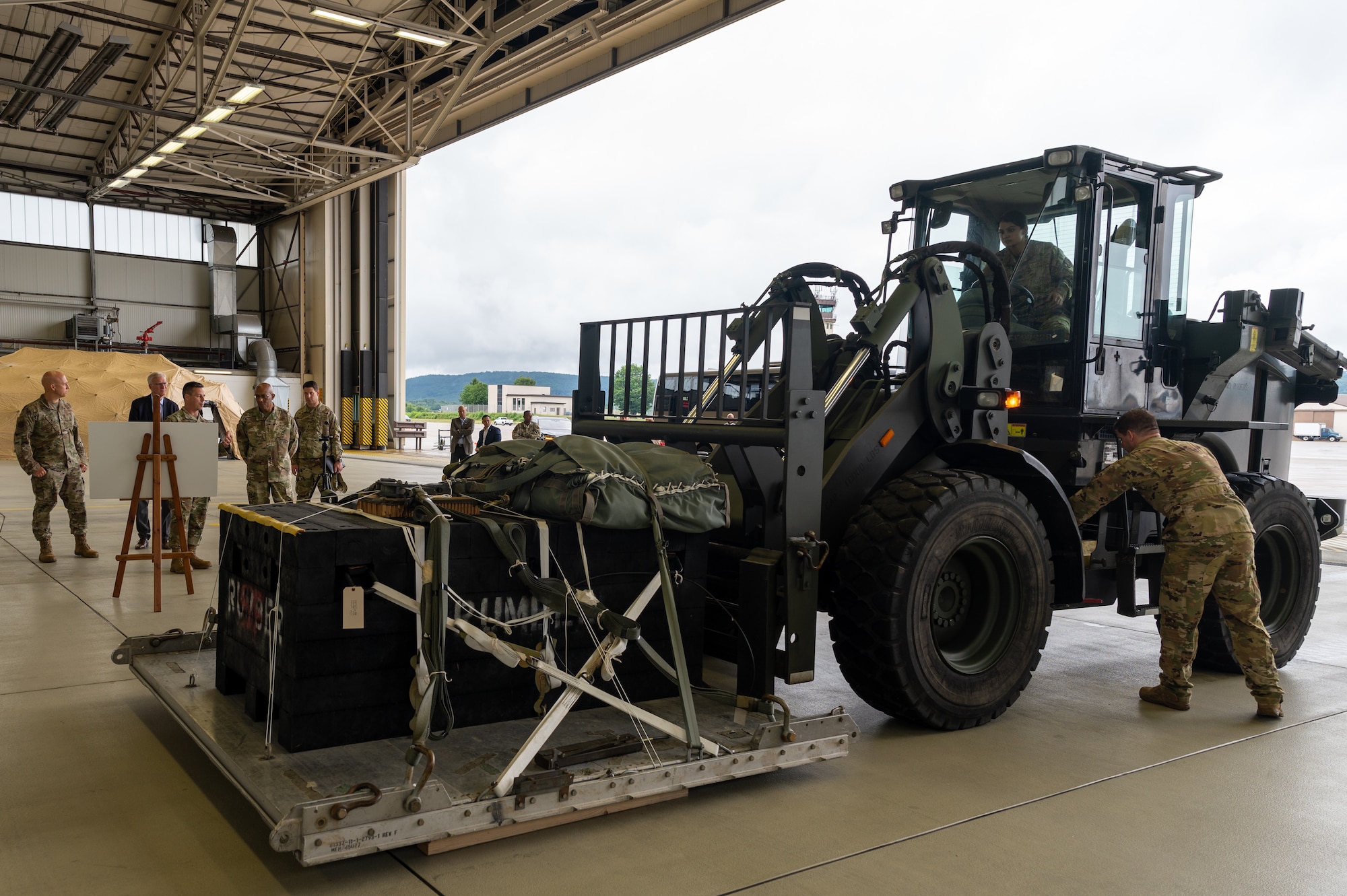 CSAF and other leadership watching Airmen operate a heavy duty forklift.