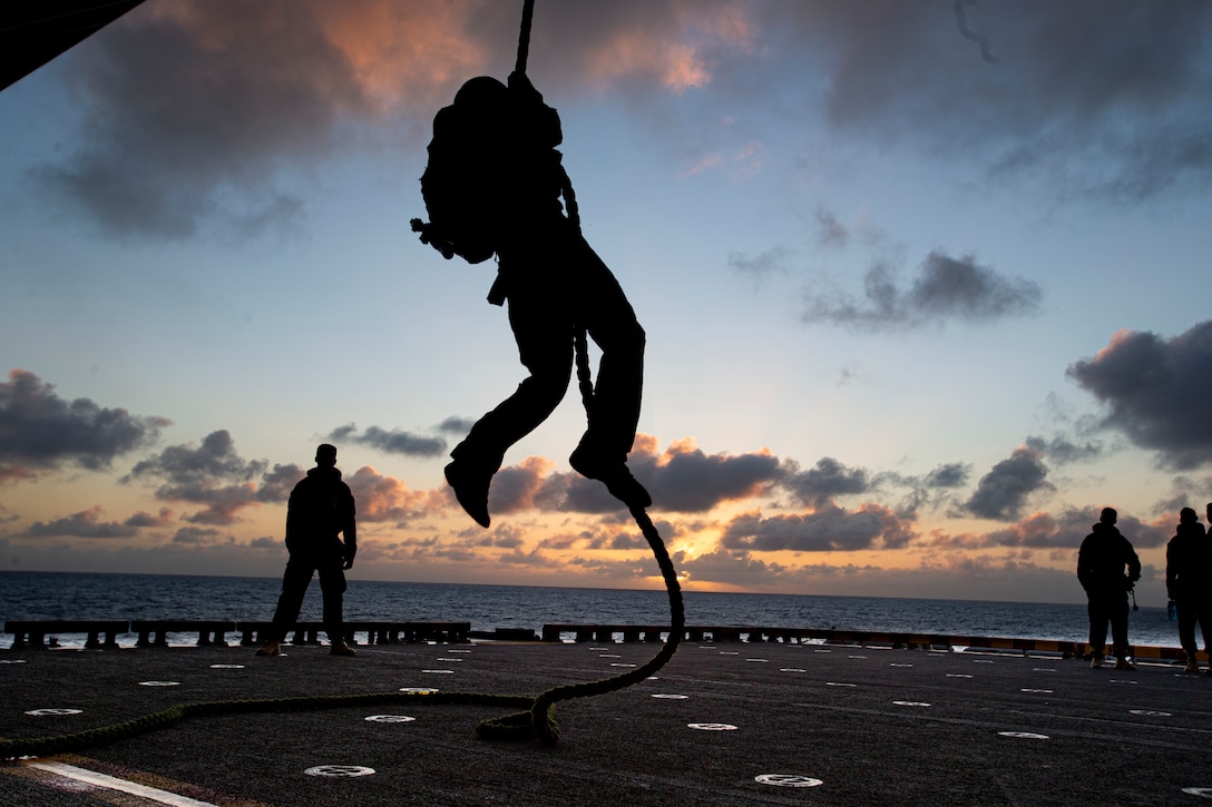 U.S. Marines with Battalion Landing Team 3/5, 31st Marine Expeditionary Unit, fast rope off a stationary MV-22B Osprey aboard the amphibious assault ship USS America (LHA 6) in the Coral Sea, July 16, 2021. Marines train to fast rope in case they are required to depart from the aircraft in a timely manner or a possible landing on uneven terrain. The 31st MEU is operating aboard ships of the America Expeditionary Strike Group in the U.S. 7th fleet area of operations to enhance interoperability with allies and partners and serve as a ready response force to defend peace and stability in the Indo-Pacific region.