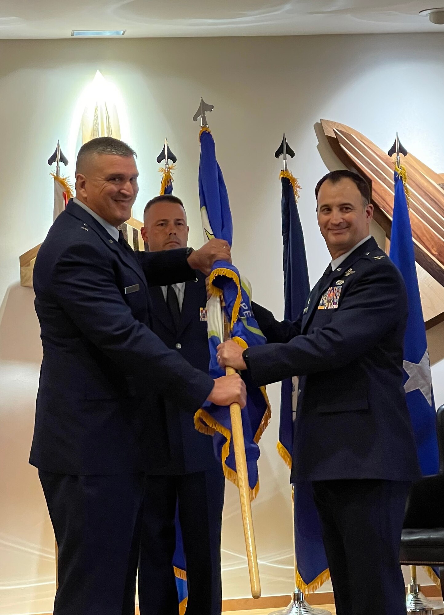 Col. Matthew Jones, former 101st Air and Space Operations Group (AOG) commander, passes the ceremonial flag to Brig. Gen. Michael Valle, Florida National Guard Assistant Adjutant General (Air), and Florida Air National Guard commander, during an AOG change of command, Tyndall Air Force Base, July 14, 2021.