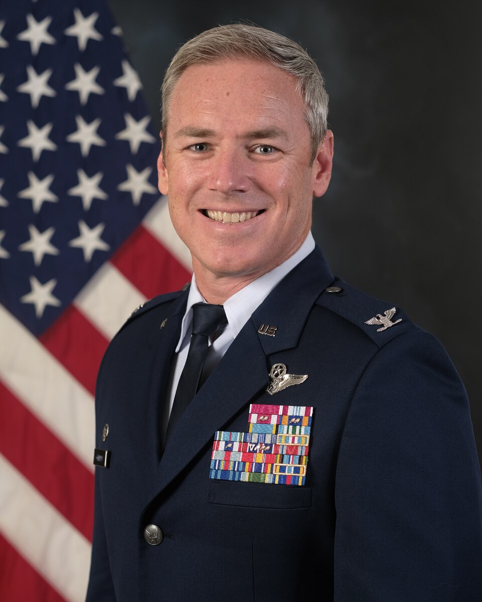 Official Photo of Colonel Frederick "Trey" Coleman III standing in front of U.S. flag.