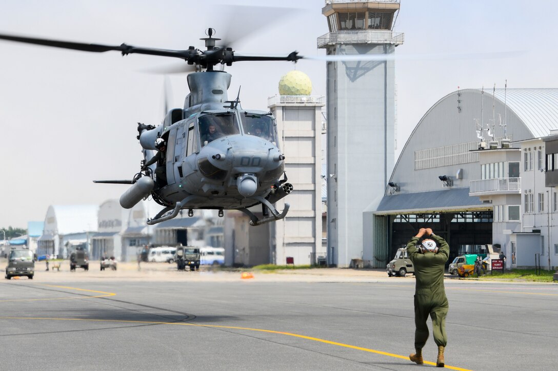 Staff Sgt. Gustavo Lopez, a Plane Captain assigned to the “Vipers” of Marine Light Attack Helicopter Squadron 169, guides an UH-1Y Venom as it arrives at Naval Air Facility Misawa. HMLA-169 is at NAF Misawa to conduct Tilt Rotor/Rotary Wing training exercises and reduce the training activity impact on Okinawa.