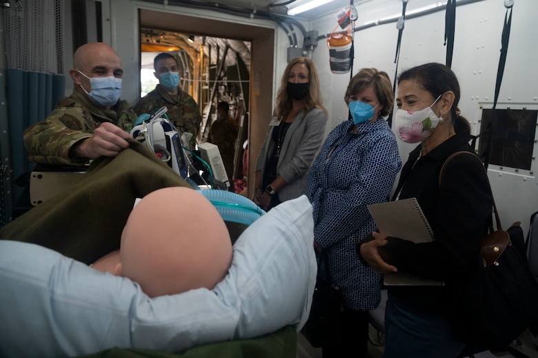 U.S. Air Force Maj. Arik Carlson, 86th Aeromedical Evacuation Squadron critical care air transport team nurse, briefs Mrs. Sharene Brown and other distinguished visitors on the 86th AES's COVID-19 patient transport procedures