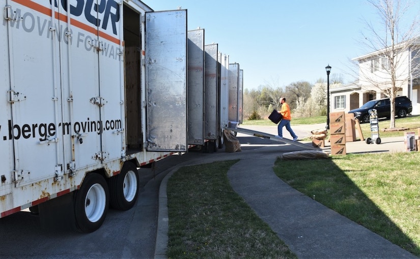 A civilian loads boxes into a truck.