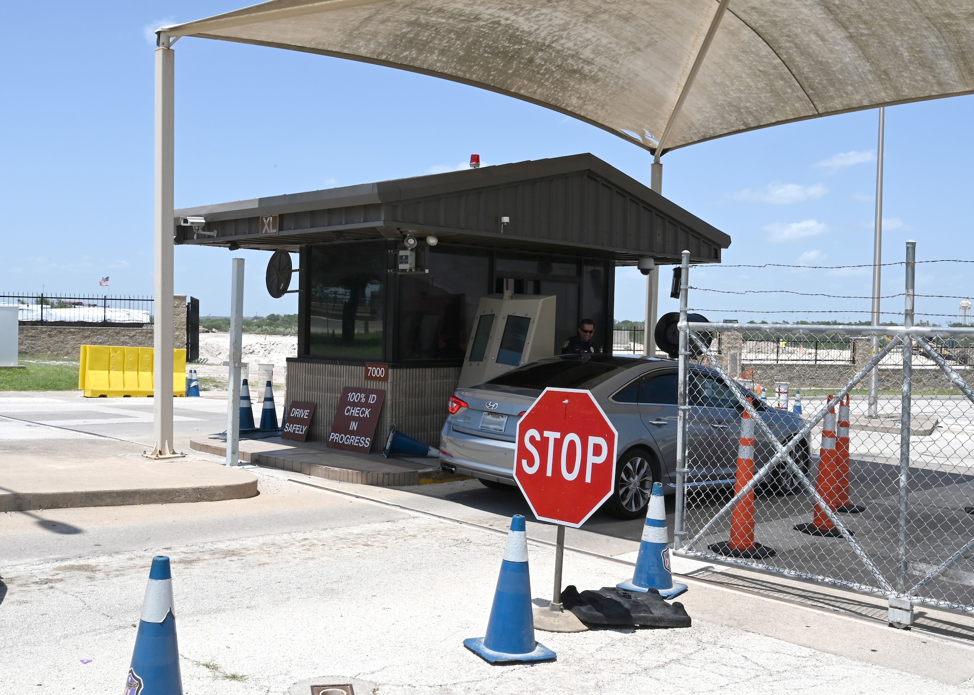 Security Forces personnel at the west gate check the identy of a passenger in an entering car on Laughlin Air Force Base, July 15, 2021. The Security Forces Personel will be changing the point of entry on July 17, 2021, to allow for upgrades to be completed to the west gate. (U.S. Air Force Photo by Senior Airman Nicholas Larsen)