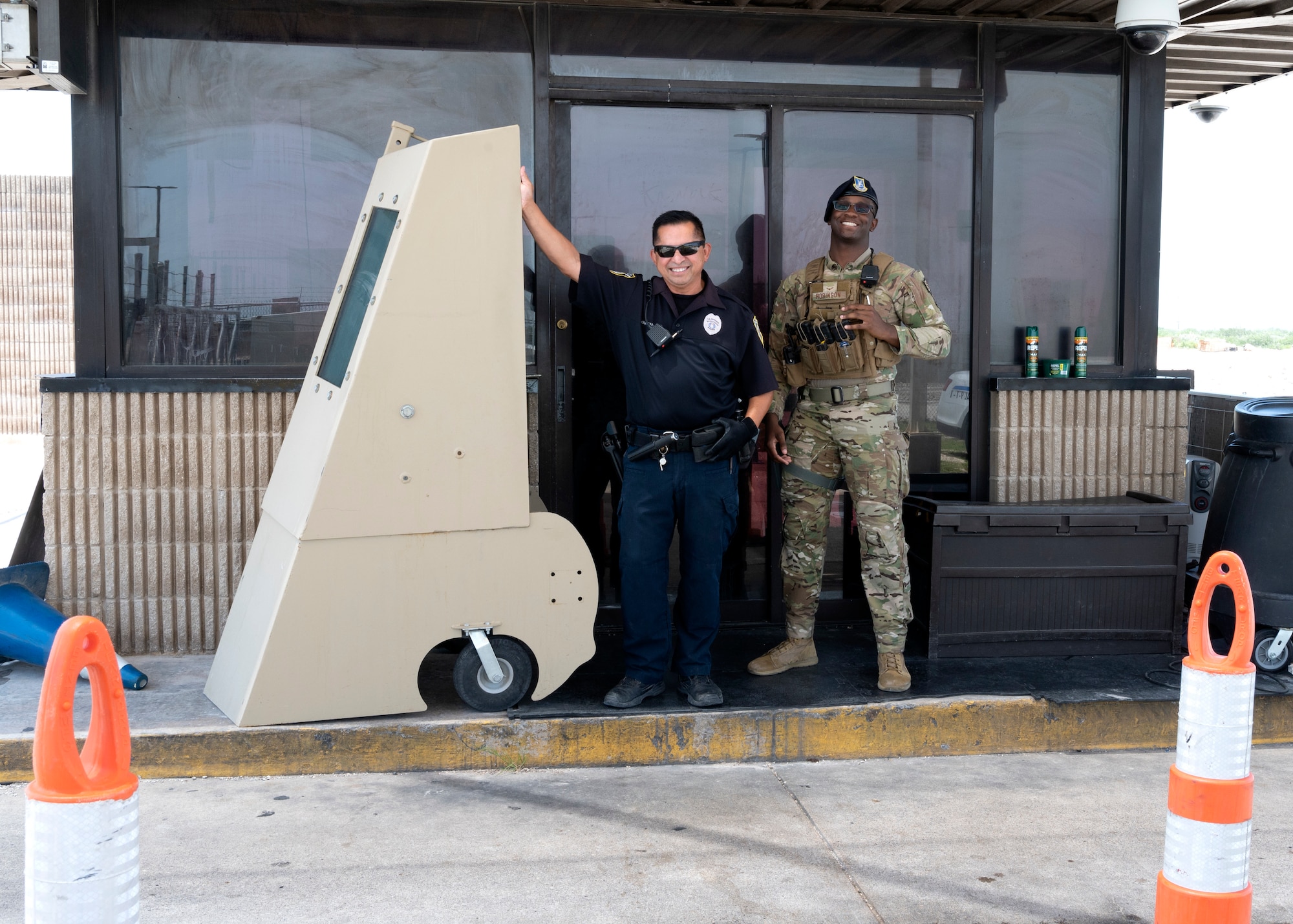 Security Forces personnel at the west gate pose for a photo behind a barrier at Laughlin Air Force Base, July 15, 2021. The Security Forces Personel will be changing the point of entry on July 17, 2021, to allow for upgrades to be completed to the west gate. (U.S. Air Force Photo by Senior Airman Nicholas Larsen)