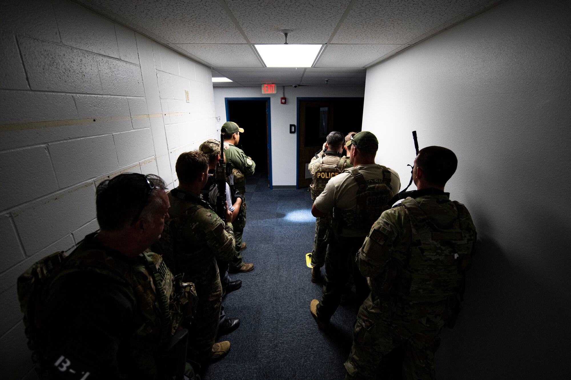 Members of the Bay County Sheriff’s Office special weapons and tactics team and 325th Security Forces Squadron tactical response team stack up in a hallway during a training exercise in Panama City, Florida, July 13, 2021. Simulated suspects were hidden throughout the building requiring the SFS and BCSO teams to work together to safely and efficiently find them. (U.S. Air Force photo by Staff Sgt. Stefan Alvarez)