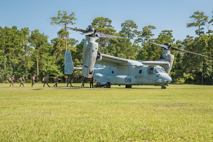 U.S. Marines with Beach and Terminal Operations Company, 2nd Landing Support Battalion, 2nd Marine Logistics Group, wait for a MV-22 Osprey to land during a company exercise on July 16, 2021 on Camp Lejeune, North Carolina. The unit utilized MV-22 Ospreys for an air insert to demonstrate their ability to establish a landing zone and provide combat service support for expeditionary amphibious basing operations. (U.S. Marine Corps photo by Cpl. Christian M. Garcia)