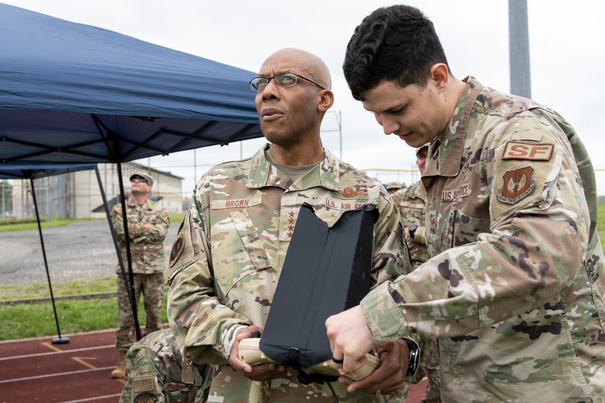 U.S. Air Force Staff Sgt. Mason Meyer, 52nd Security Forces Squadron Base Defense Operations Center controller (right), demonstrates operating an unmanned aerial vehicle with U.S. Air Force Chief of Staff Gen. CQ Brown Jr. July 16, 2021, on Spangdahlem Air Base, Germany.