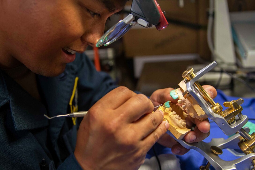 A sailor works on a bite mold.