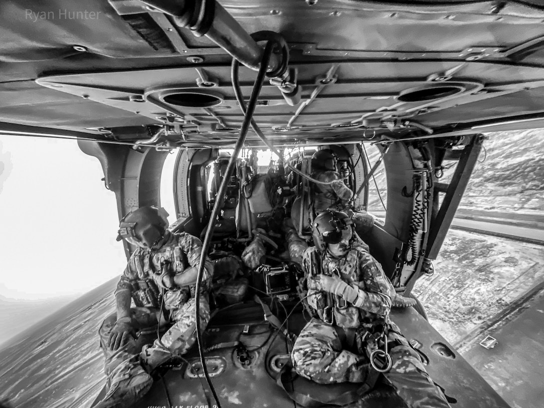 Staff Sgt. Stephen Parker and Staff Sgt. Shaun Morris, along with pilots, Capt. Jonathan Strayer and Chief Warrant Officer Kristan Beard, conduct hoist and joint MEDEVAC training with U.S. Marines over New Antonik, Afghanistan July 2020.