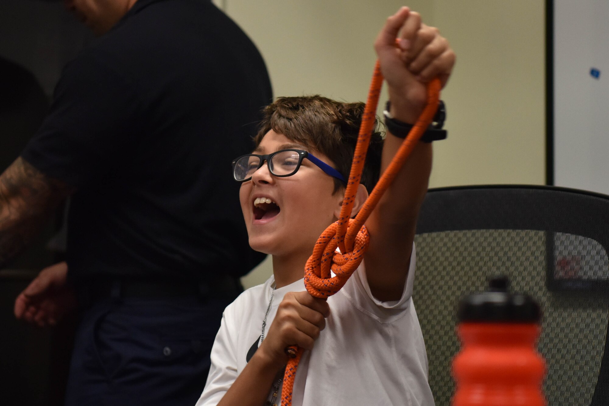 Junior firefighter, Samuel Sprang, holds up a knot in celebration during the Junior Firefighter Camp on Goodfellow Air Force Base, Texas, July 14, 2021. Samuel and the other junior firefighters learned to tie several knots used for various situations. (U.S. Air Force photo by Senior Airman Jermaine Ayers)