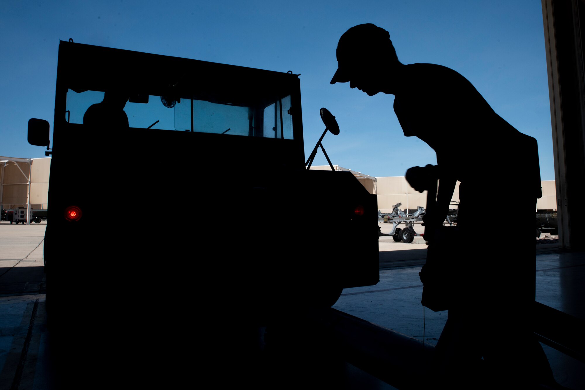 A photo of an Airman signaling a truck