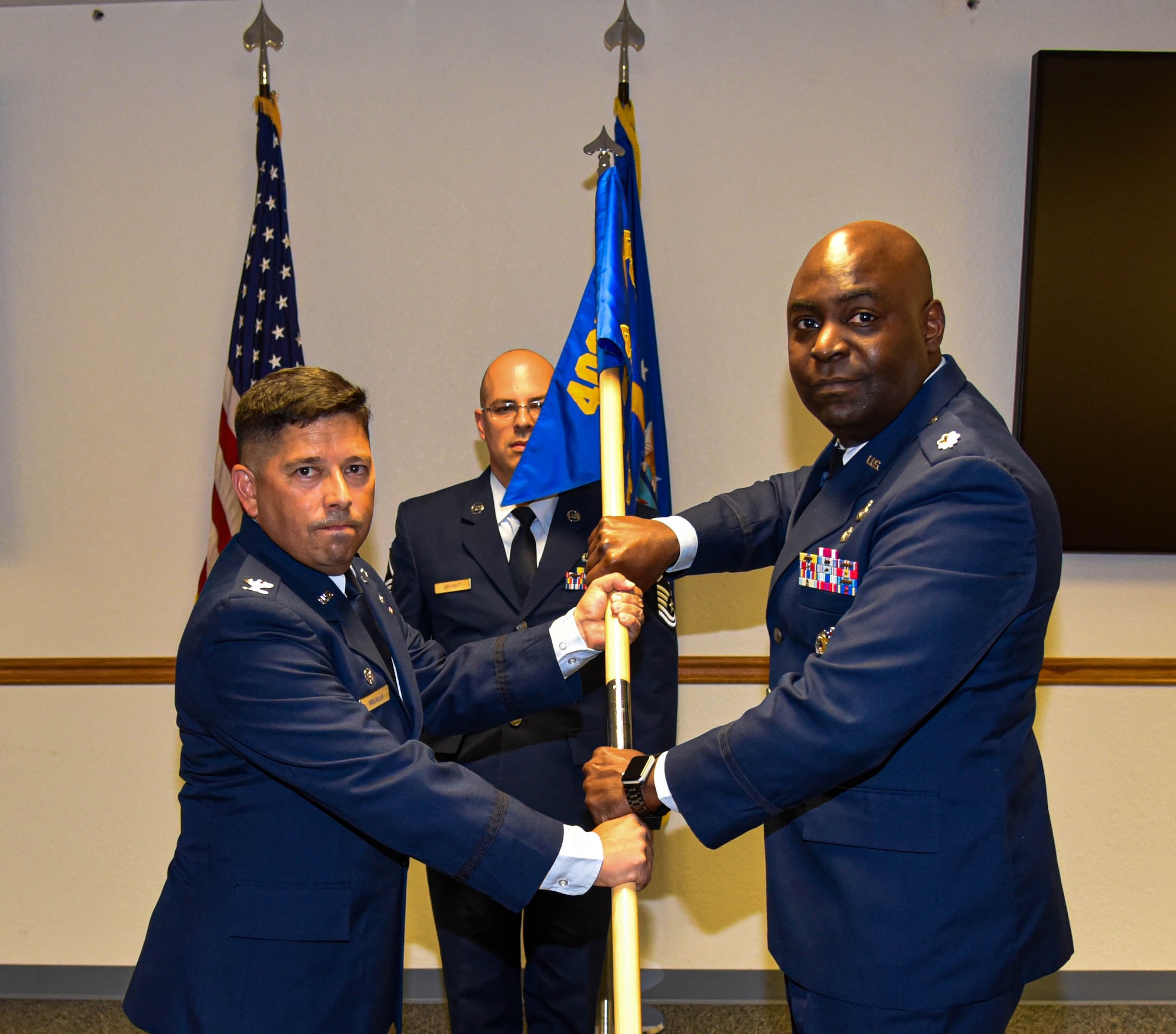 Lt. Col. Costau C. Bastien (right), commander, 403rd Force Support Squadron accepts the 403rd Force Support Squadron guidon from Col. Reggie Trujillo (left), commander, 403rd Mission Support Group during an assumption of command ceremony in the Sablich Center auditorium at Keesler Air Force Base, Miss. July 10, 2021. (U.S. Air Force photo by Tech. Sgt. Michael Farrar)