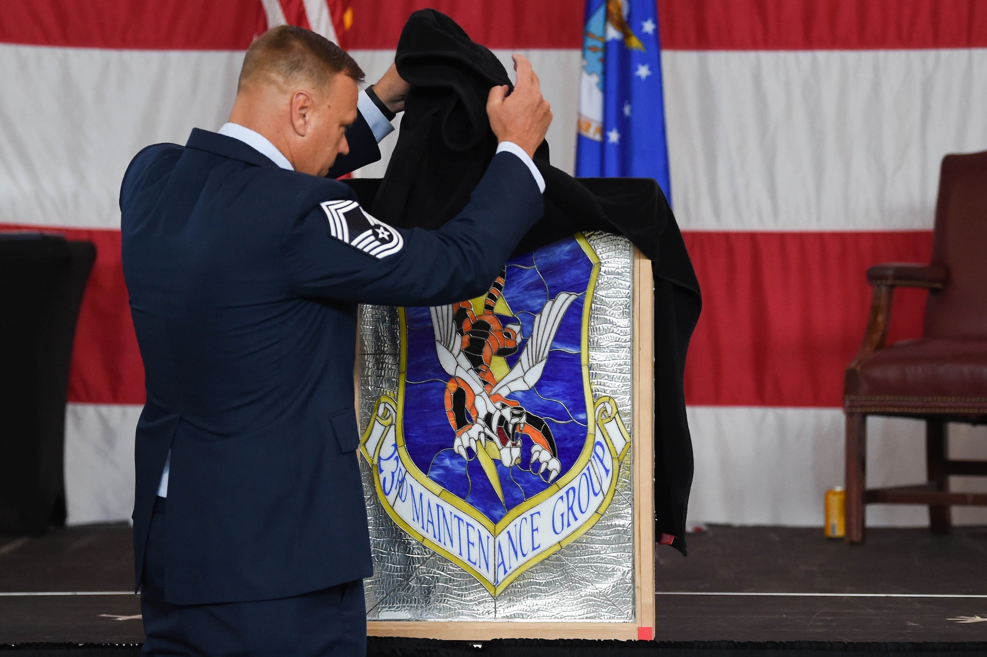A photo of an Airman unveiling a plaque