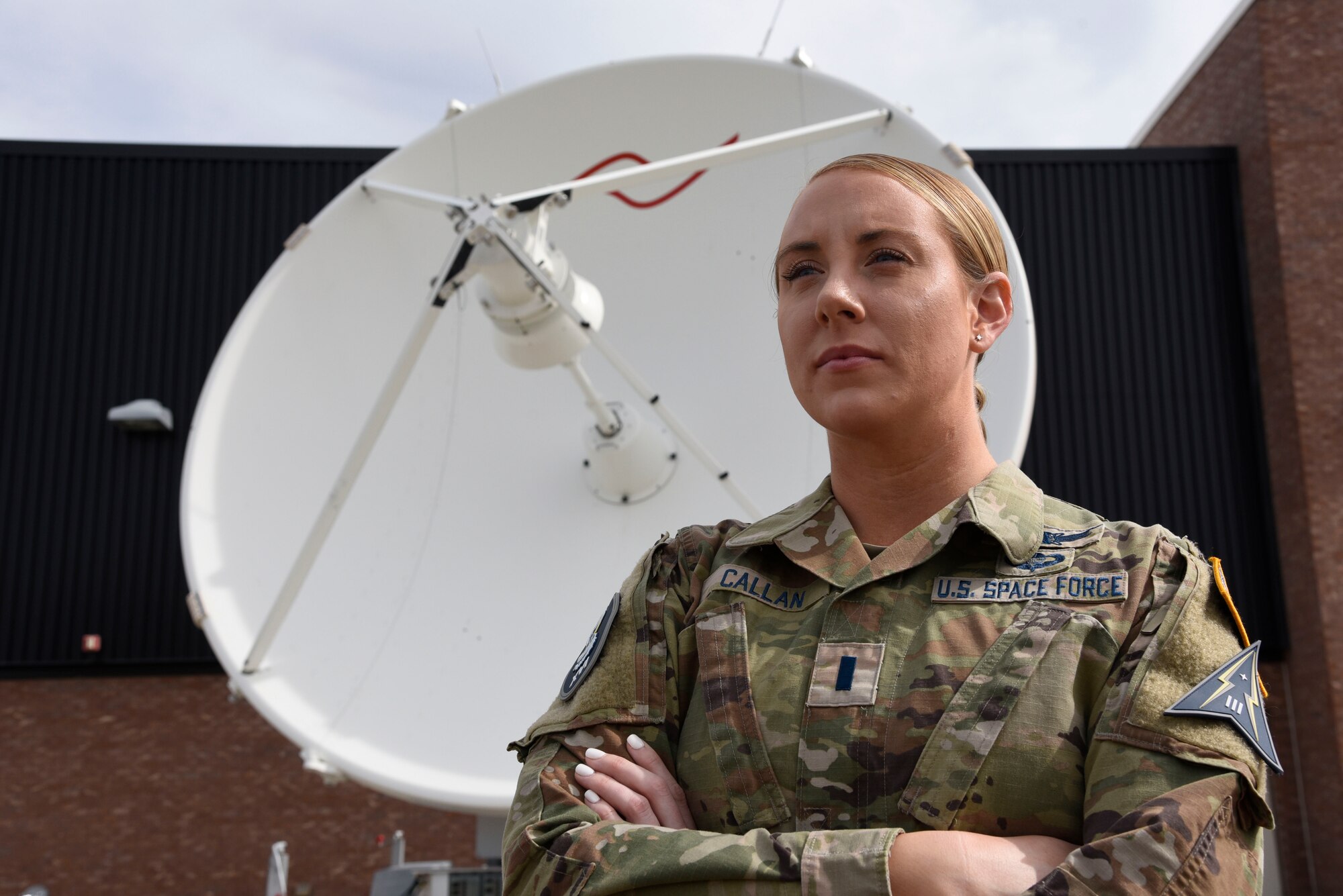 1st Lt. Monica Callan stands in front of a training satellite dish