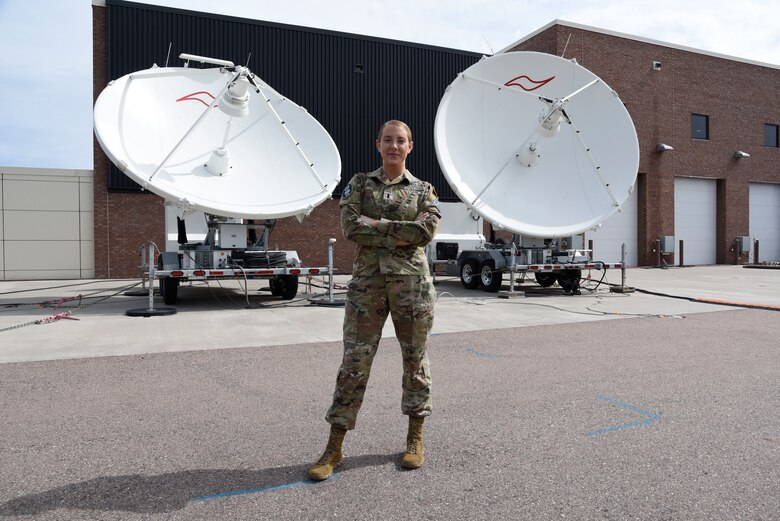 1st Lt. Monica Callan stands in front of a training satellite dish