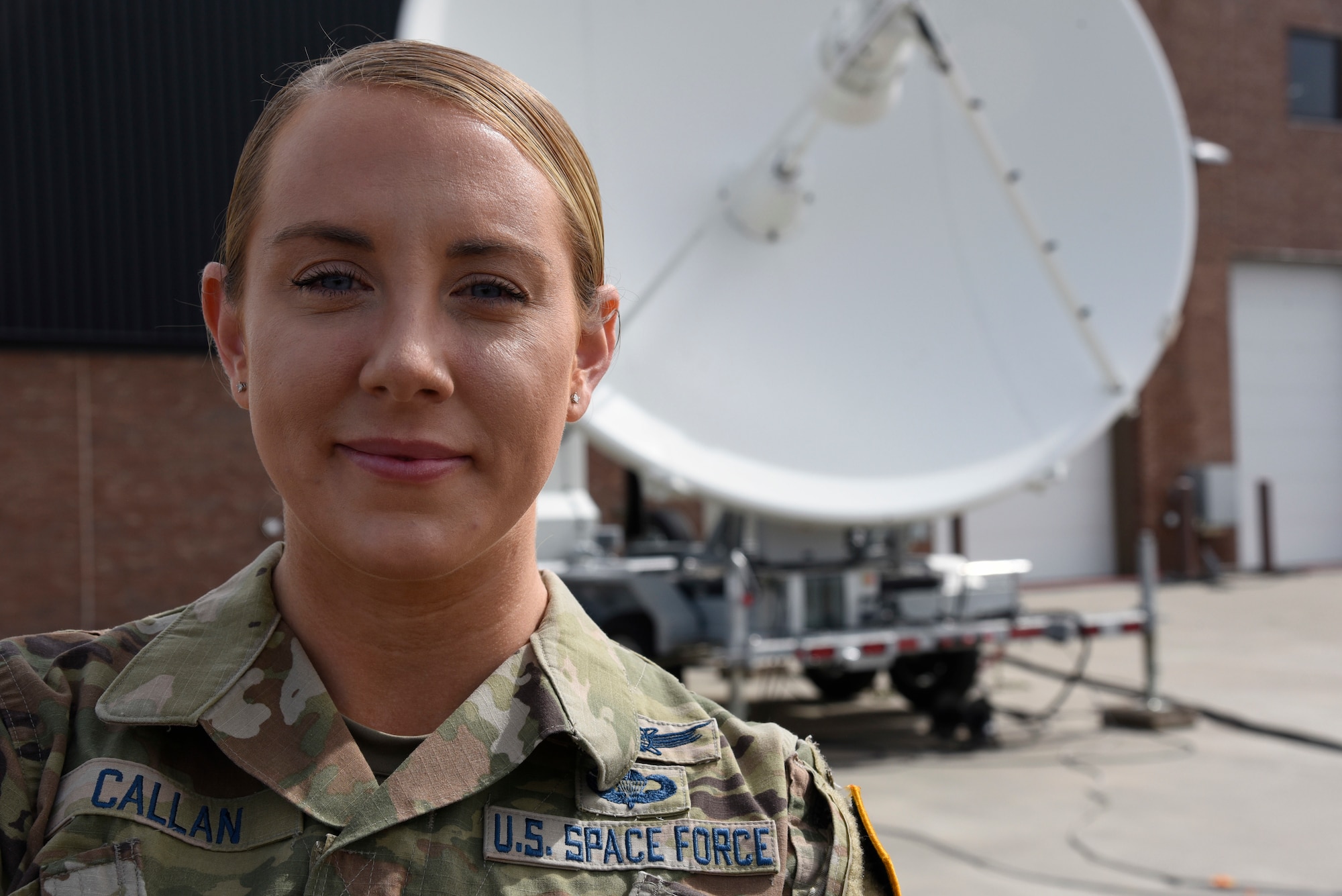 1st Lt. Monica Callan stands in front of a training satellite dish