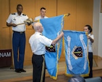 Army Lt. Gen. Ronald J. Place, director of the Defense Health Agency, unfurls the DHA flag