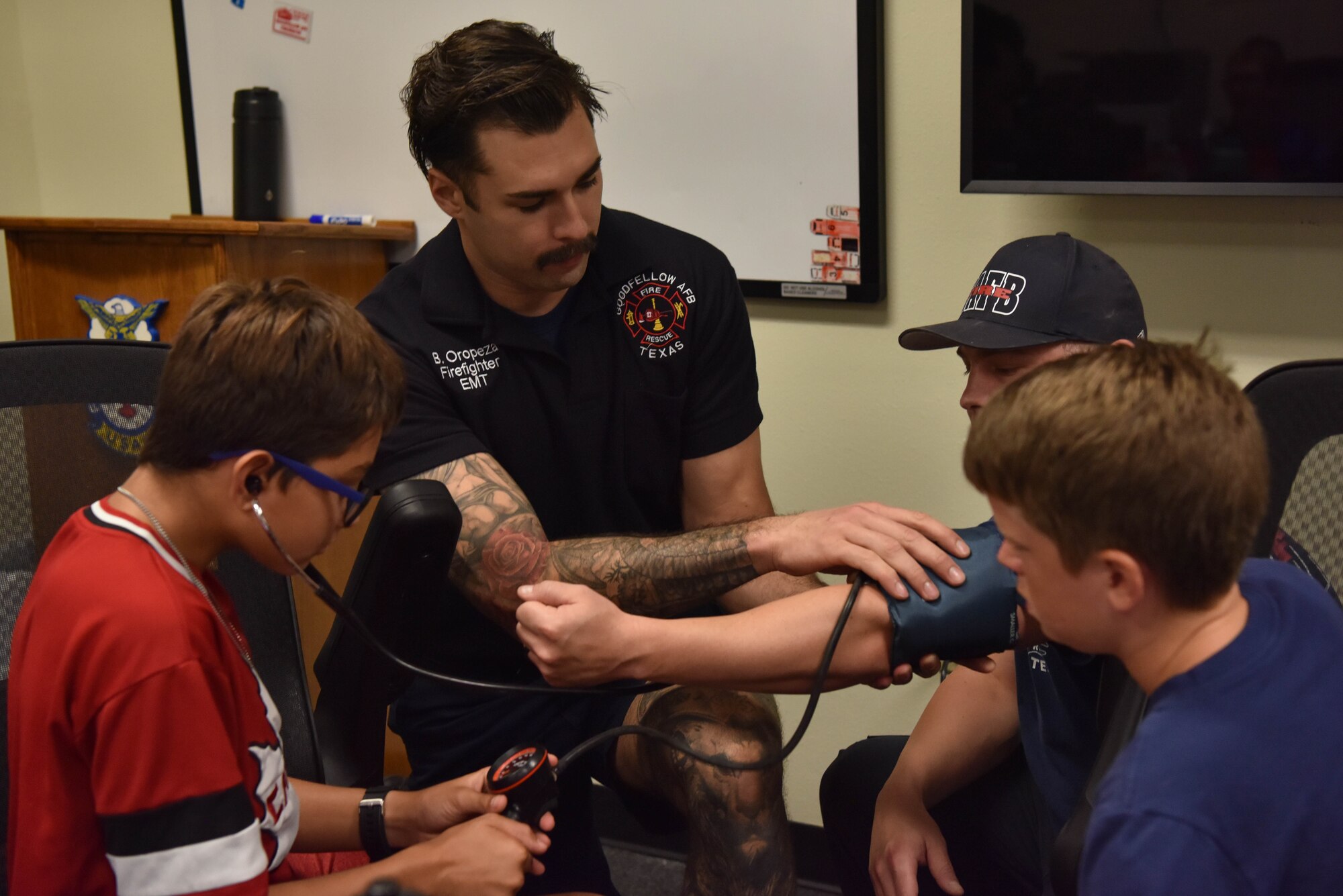 17th Civil Engineer Squadron firefighter, Brandon Oropeza, demonstrates to junior firefighters how to use first-aid equipment during the Junior Firefighter Camp on Goodfellow Air Force Base, Texas, July 12, 2021. Junior firefighters were taught how to check patient’s blood pressure, bandage wounds, and how to properly use a stethoscope when monitoring a subject’s heartbeat. (U.S. Air Force photo by Senior Airman Jermaine Ayers)