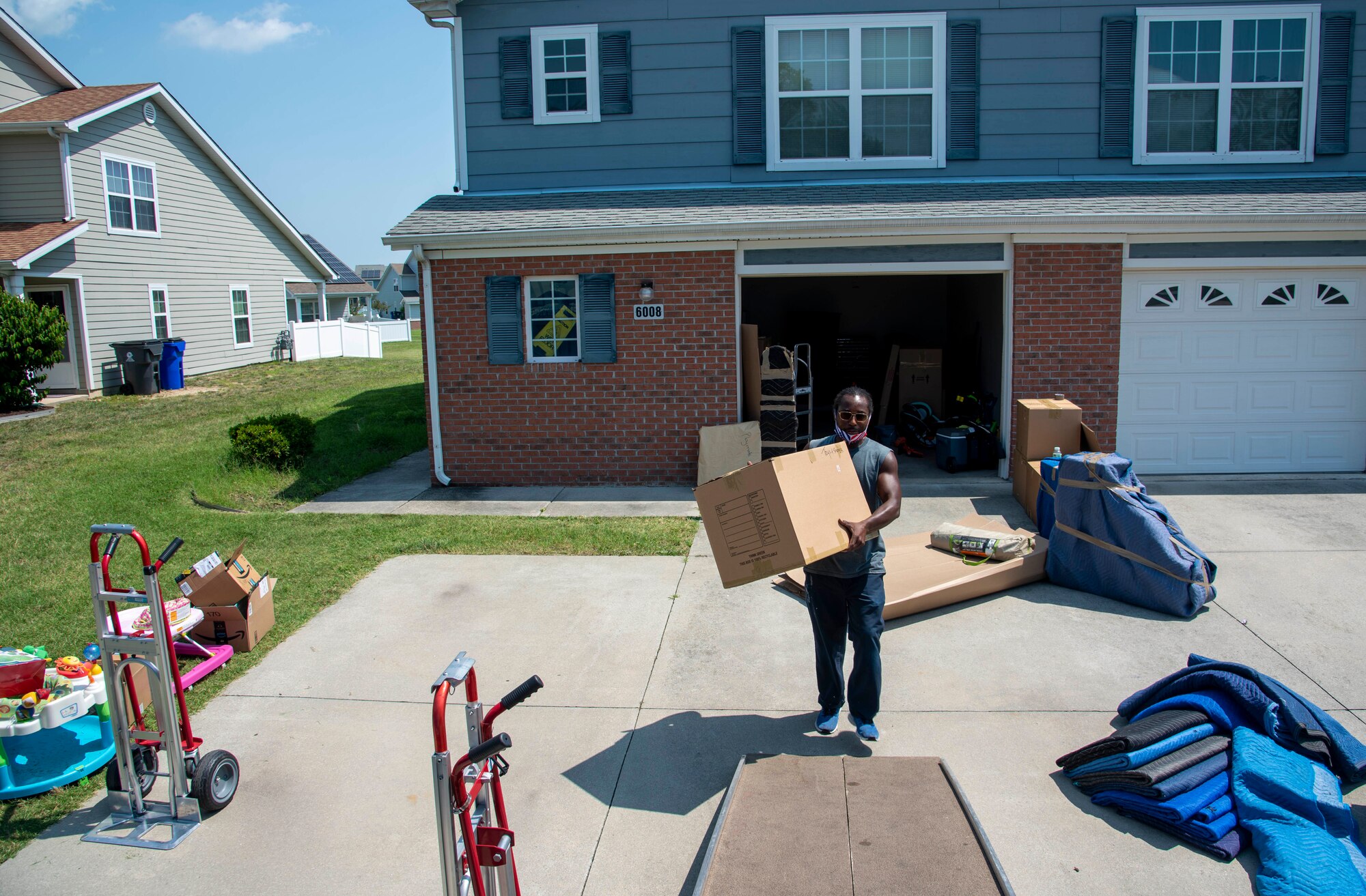 Barry Bull, Barry Van Lines mover, carries a box of household goods onto a moving truck on Dover Air Force Base, Delaware, July 16, 2021. Dover AFB and the Air Force Aid Society provide 20 hours of free permanent change of station care for each child upon arrival to and departure from their duty stations. (U.S. Air Force photo by Tech. Sgt. Nicole Leidholm)