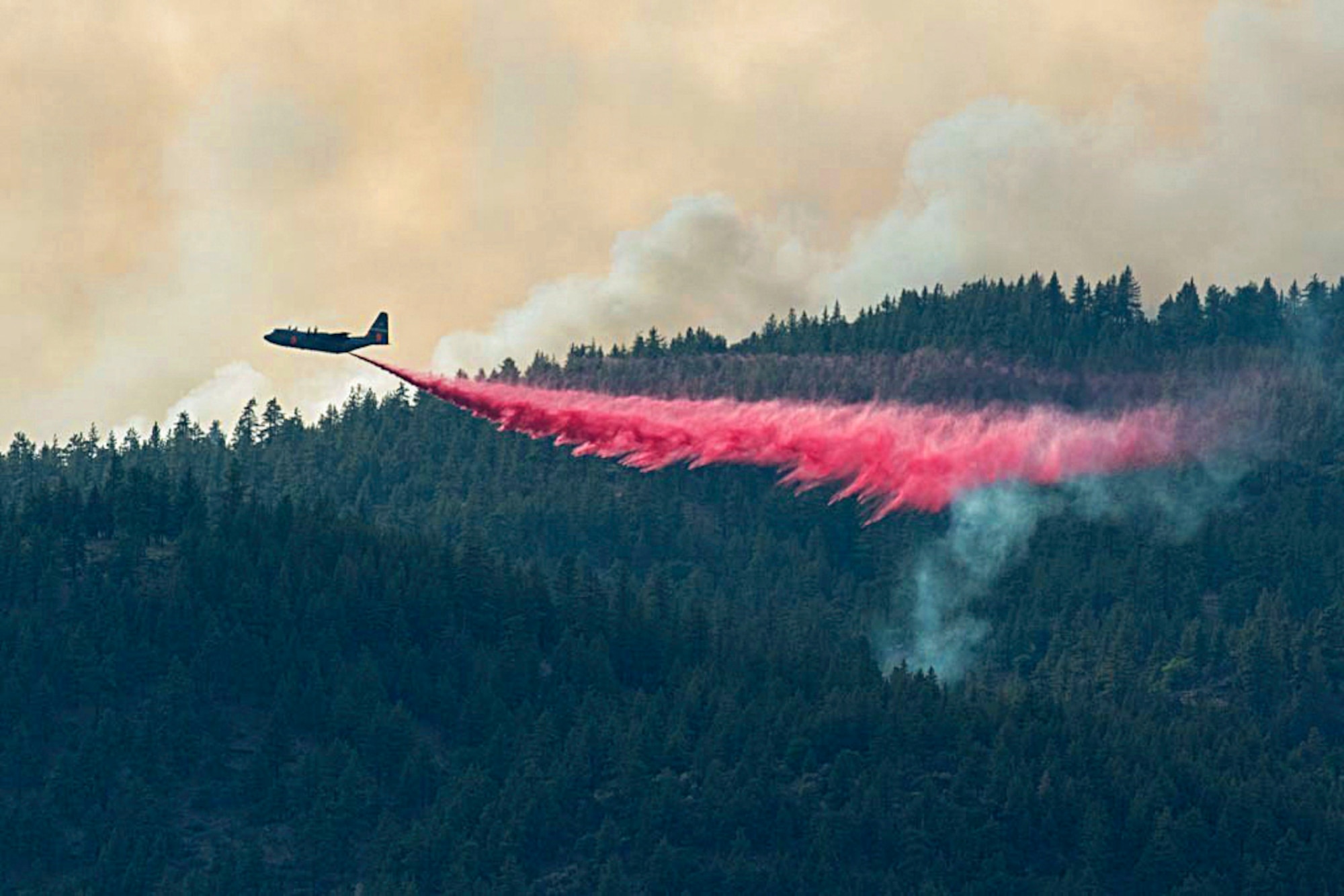 Air National Guard C-130 drops retardant on the Beckwourth Complex Fire July 9, 2021 near Frenchman Lake in N. California