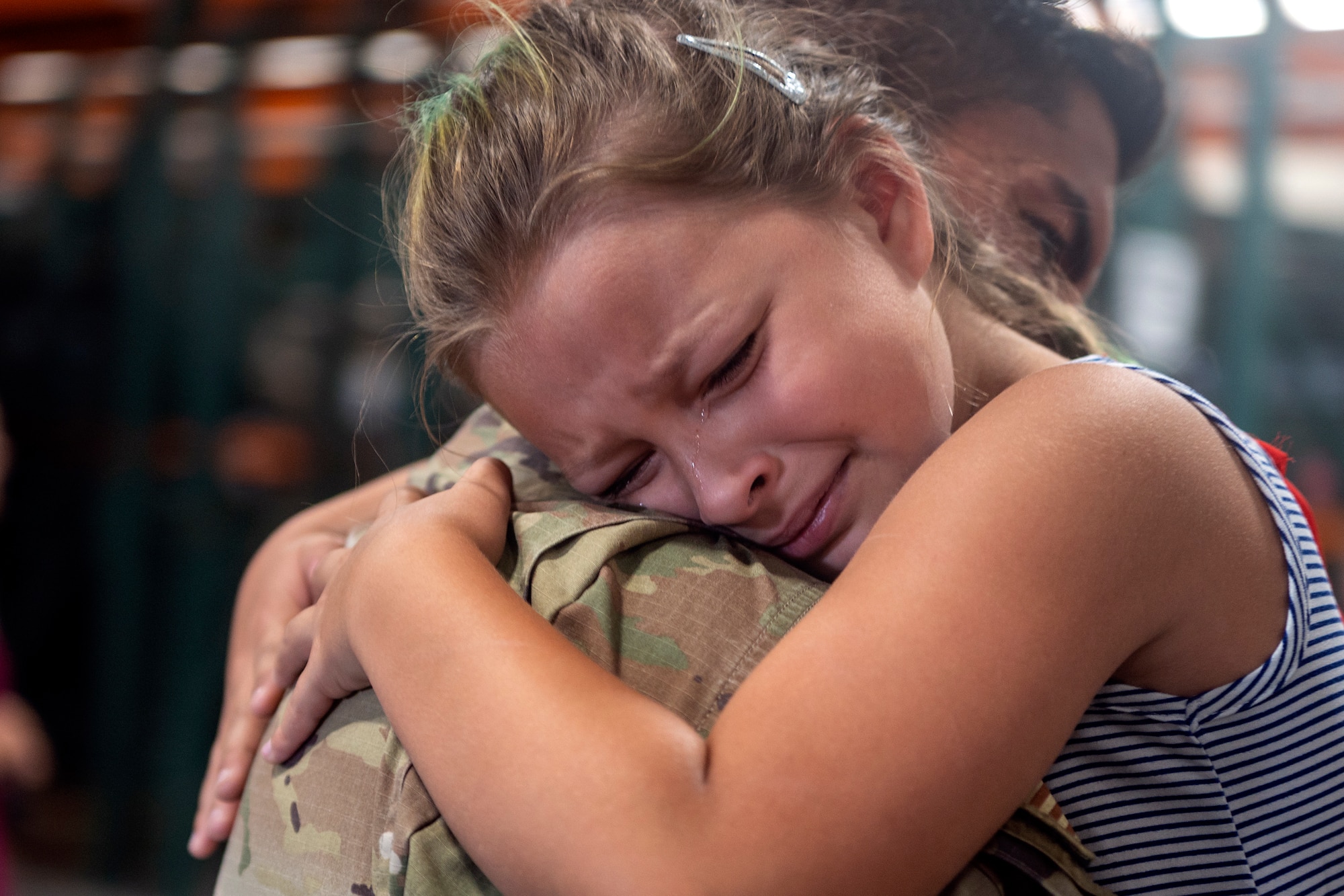 Gianna, 9, hugs Tech. Sgt. Steve Rogers, 921st Contingency Response Squadron aerial porter supervisor, at the Global Reach Deployment Center June 19, 2021, after arriving to Travis Air Force Base, California. Members of the 621st Contingency Response Wing assisted retrograde operations in U.S. Central Command’s area of responsibility to withdraw personnel and cargo out of the AOR. (U.S. Air Force photo by Master Sgt. David W. Carbajal)