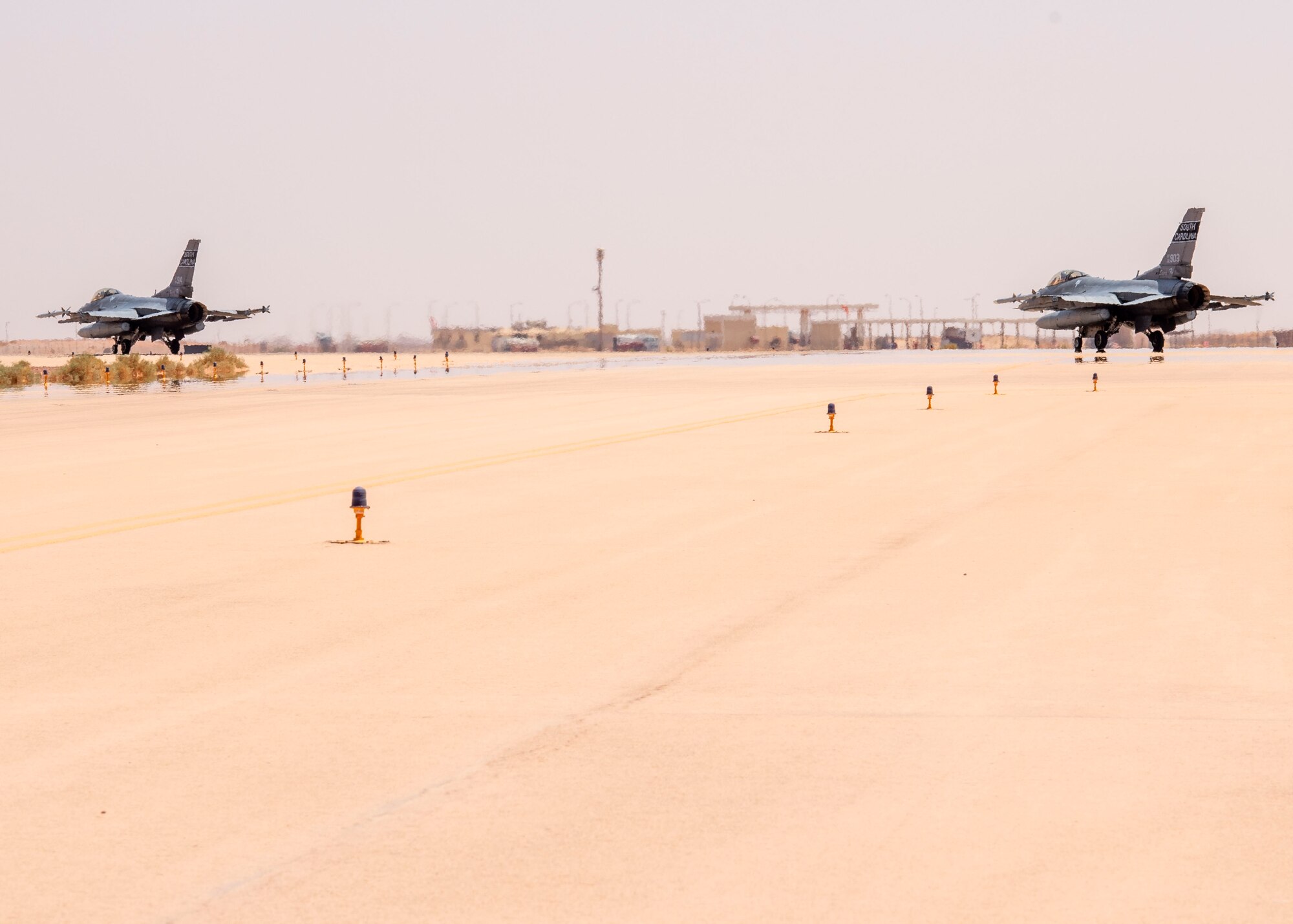 Two U.S. Air Force F-16 Fighting Falcons taxi on a runway at Prince Sultan Air Base, Kingdom of Saudi Arabia, while preparing to take part in a counter unmanned aerial system integration mission with joint and Royal Saudi aircraft, June 30, 2021. U.S. Air Forces Central aircraft regularly work with coalition and partner nations to test their collective counter-UAS capabilities to ensure the security and stability of regional airspace.  (U.S. Air Force photo by Technical Sgt. Veronica Woodward)