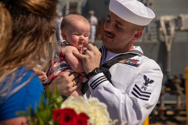 Logistics Specialist 1st Class Patrick Harris, assigned to the Arleigh Burke-class guided-missile destroyer USS Thomas Hudner (DDG 116), meets his newborn daughter for the first time following the ship’s return from deployment.