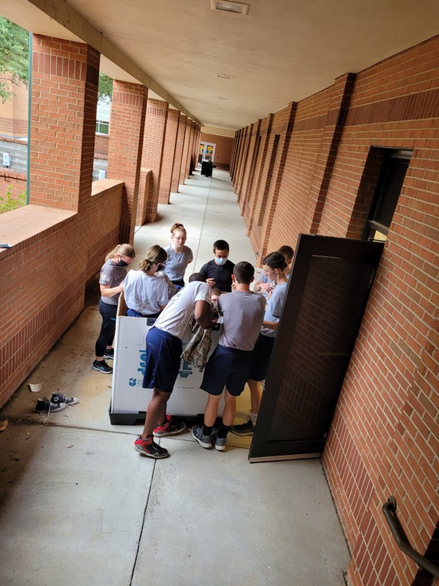 group of teens grabbing uniforms from a box