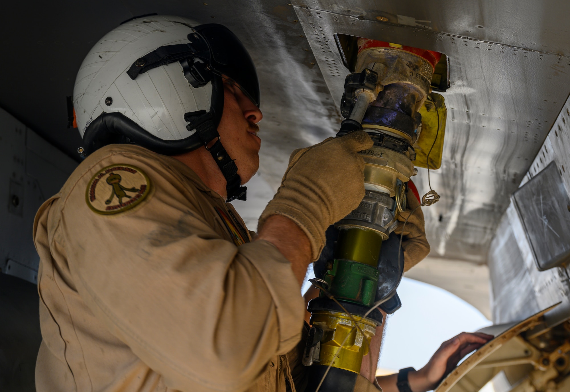 A U.S. Marine with Marine Aerial Refueler Transport Squadron 352, assigned to Special Purpose Marine Air-Ground Task Force – Crisis Response – Central Command, attaches a fuel hose to “hot pit” refuel a U.S. Air Force F-16 Fighting Falcon during a counter unmanned aerial system integration mission with joint and Royal Saudi aircraft at a forward location in the Kingdom of Saudi Arabia, June 30, 2021. U.S. Air Forces Central aircraft regularly work with coalition and partner nations to test their collective counter-UAS capabilities to ensure the security and stability of regional airspace. (U.S. Air Force photo by Senior Airman Samuel Earick)