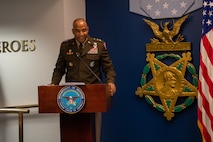 man sends behind a podium and gives a speech.