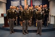 Man stands behind a podium on a stage wearing an army uniform.