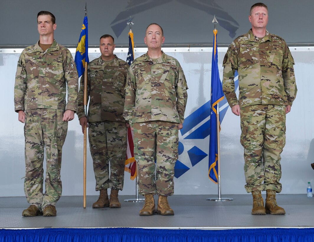 four men standing at attention in uniform