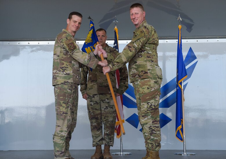 two men holding a flag and posing