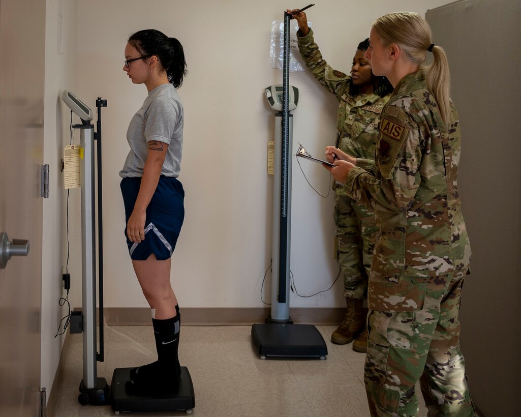 Fitness assessment cell technicians measure Airman’s weight and height prior to conducting a fitness assessment at Seymour Johnson Air Force Base, North Carolina, July 13, 2021.