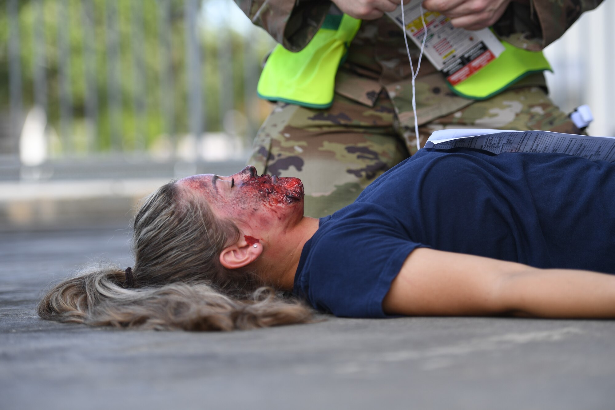U.S. Air Force Airman Kelsey Wozniak, 81st Medical Support Squadron medical technician student, portrays an injured victim during an 81st Medical Group functional exercise behind the Keesler Medical Center at Keesler Air Force Base, Mississippi, July 15, 2021. The scenario involved a chlorine cylinder explosion causing chemical burns and other injuries on several victims. The mass casualty exercise was held to prepare for real-world events by strengthening disaster medical response capabilities. (U.S. Air Force photo by Kemberly Groue)