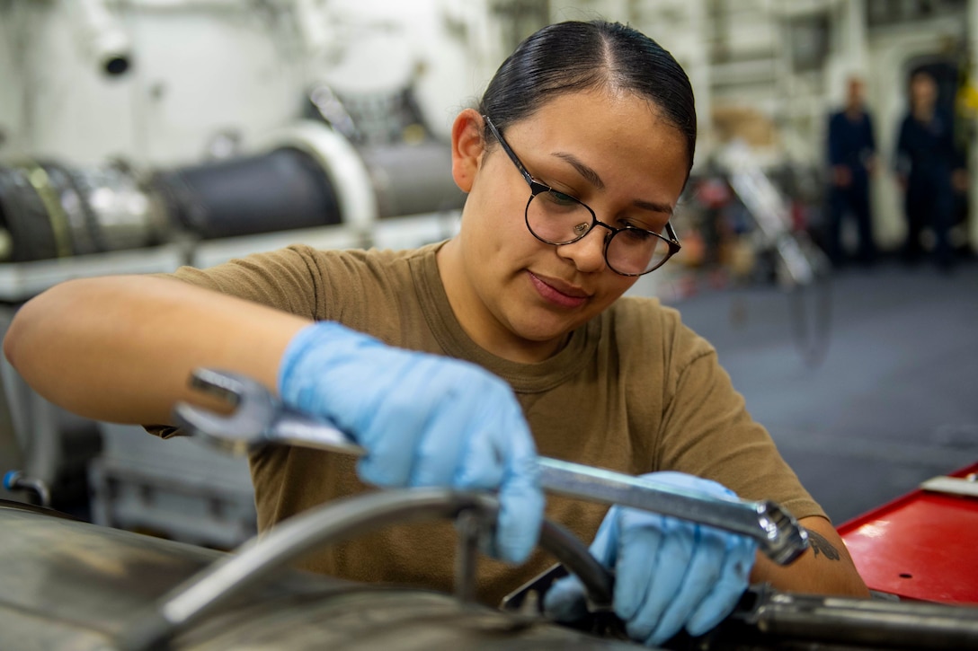 A sailor works on an aircraft.