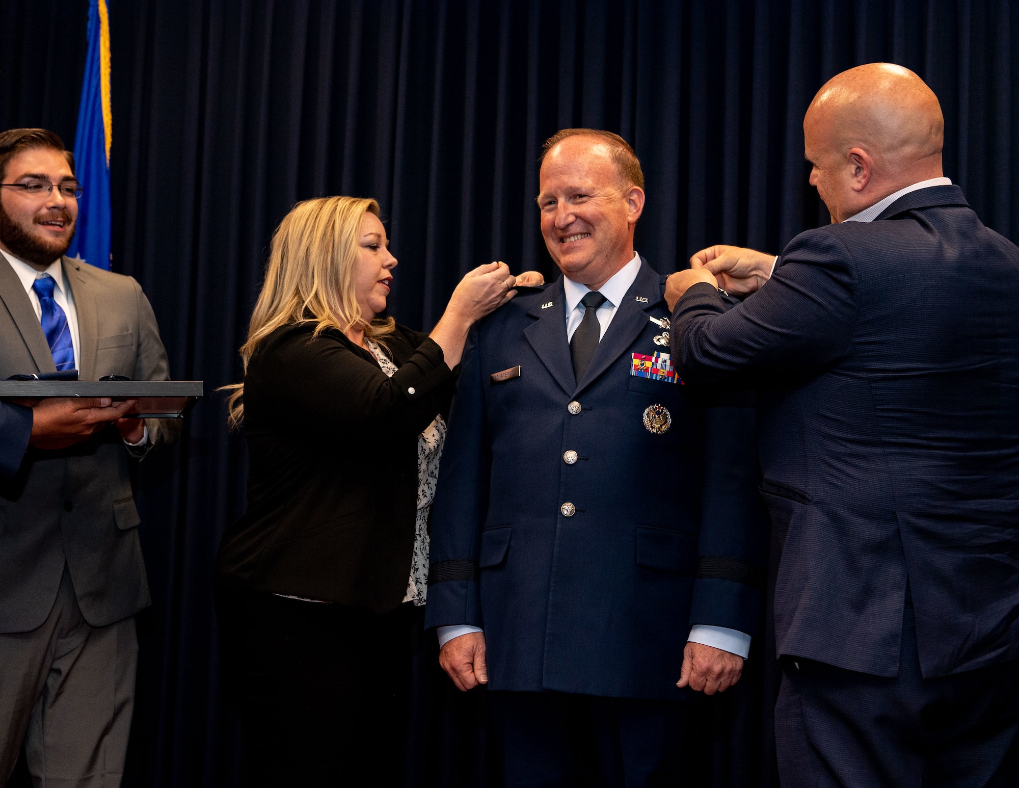 Maj. Gen. Anthony W. Genatempo, Air Force Nuclear Weapons Center commander and Air Force program executive officer for strategic systems, is pinned with the rank of Major General by his sister-in-law and brother, Cari and Mark Genatempo, with assistance from his son, Rett Genatempo (far left), during a promotion celebration at Kirtland Air Force Base, New Mexico, on July 9, 2021, His official promotion date was May 7, but the celebration was delayed to allow family and friends to attend after pandemic restrictions were eased. (U.S. Air Force photo by Allen Winston)