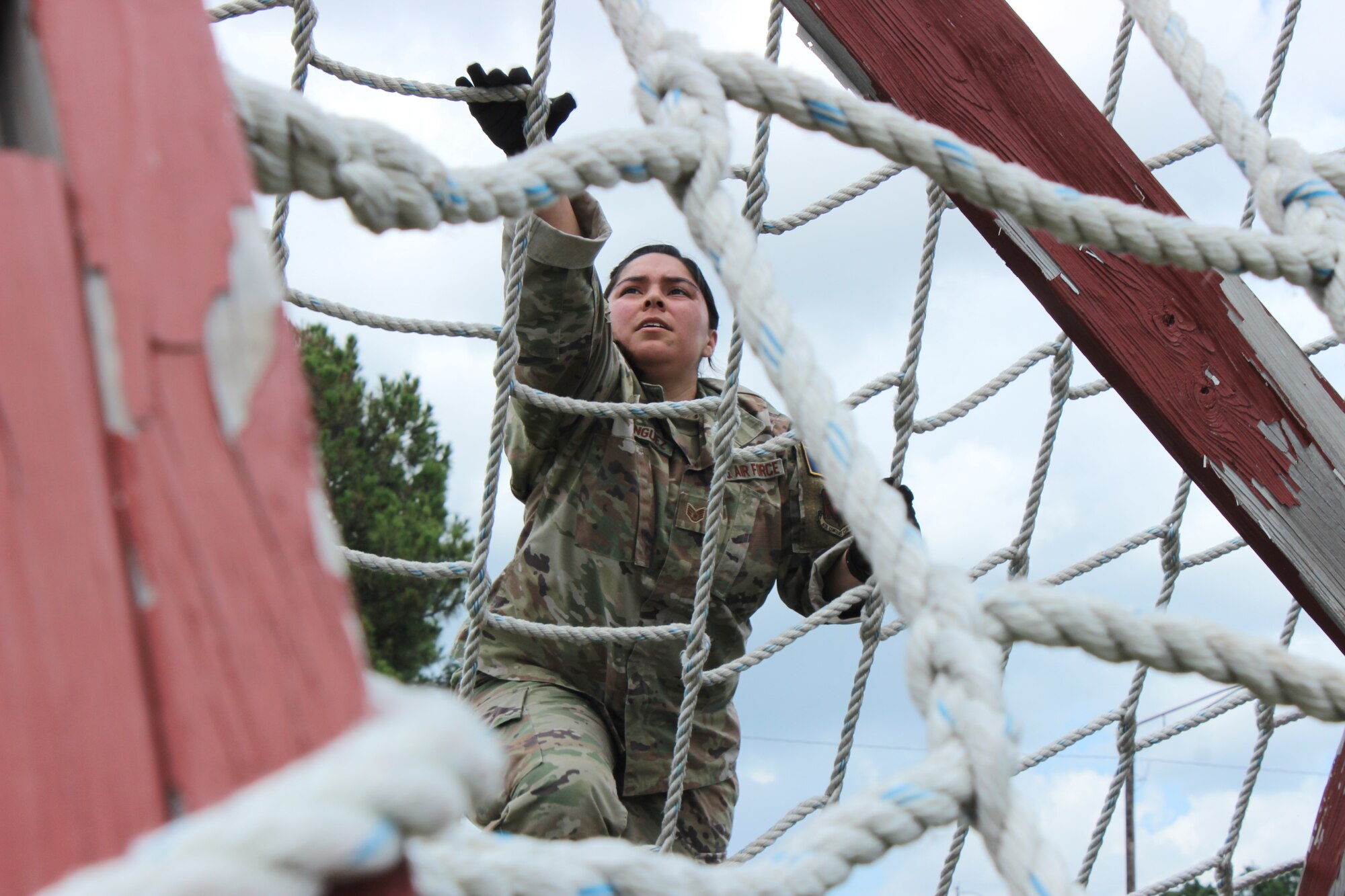 woman climbing obstacle course cargo net