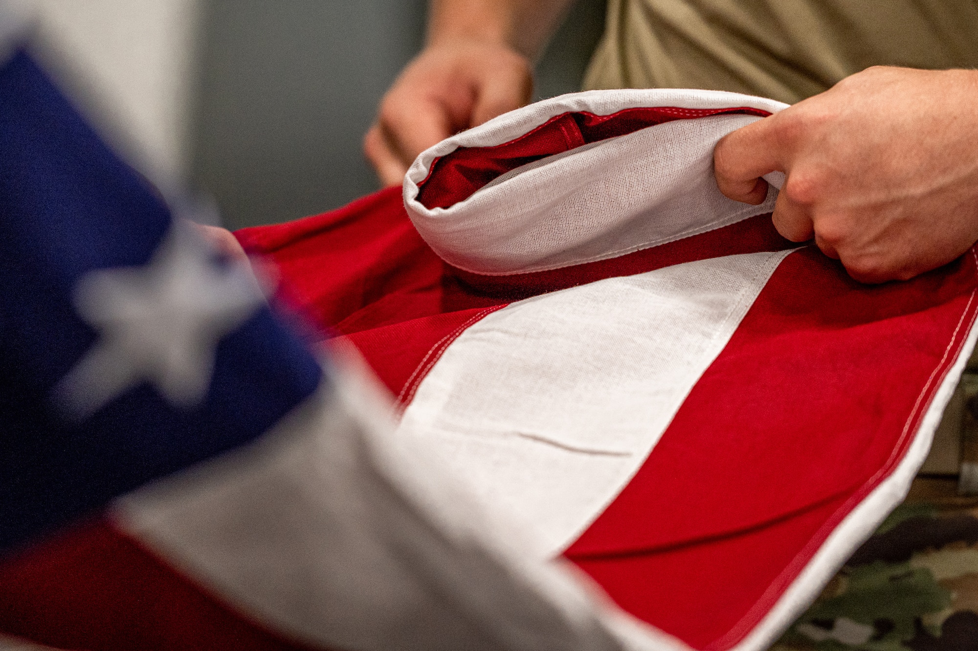 U.S. Air Force Senior Airman Dana Gilbert, 375th Operation Support Squadron air traffic controller, folds a flag on Scott Air Force Base, Illinois, July 9, 2021. Ceremonial guardsmen have to follow a strict code of conduct that they train in and follow for ceremonies. (U.S. Air Force Photo by Airman 1st Class Isaac Olivera)