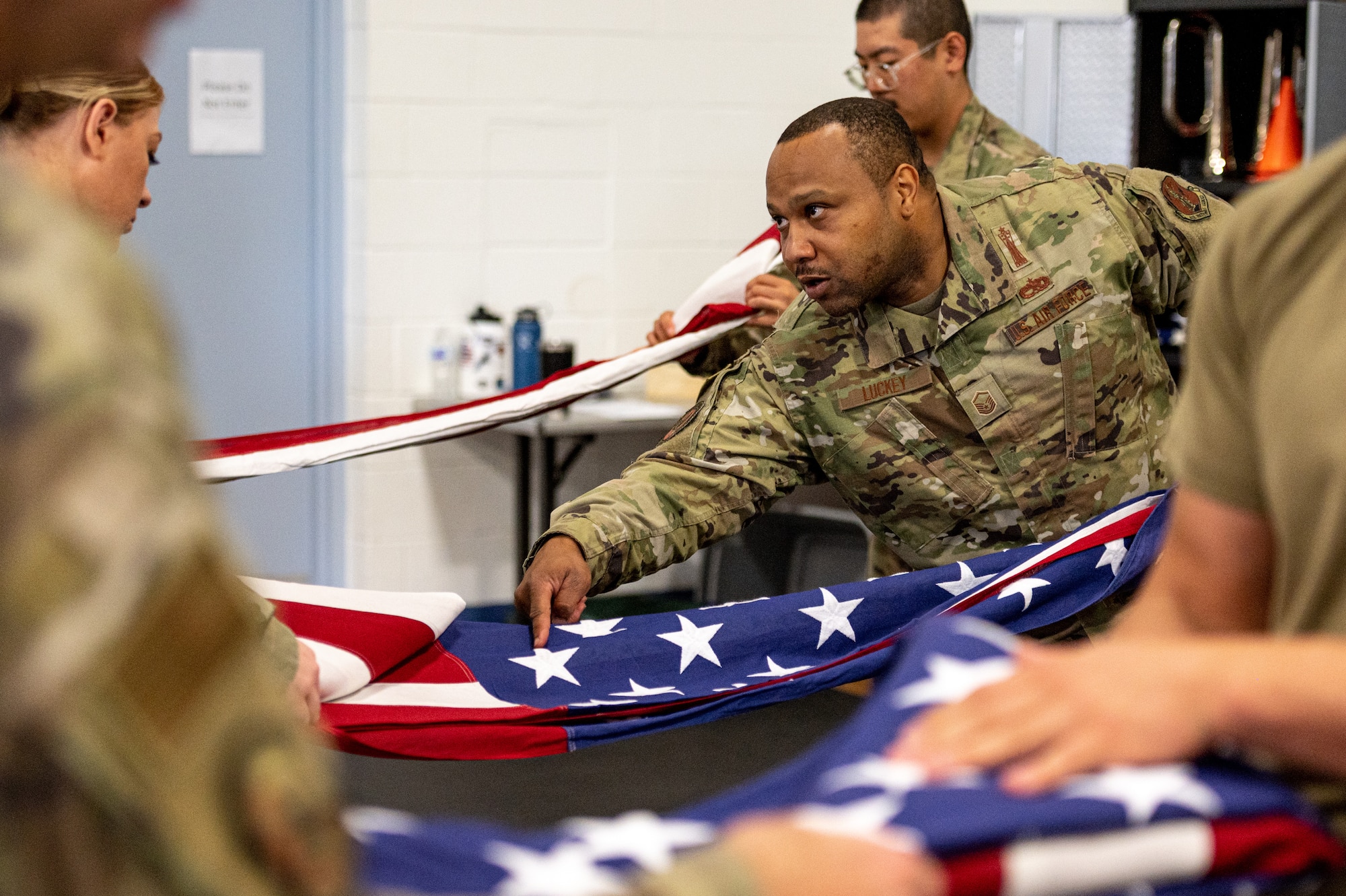 U.S. Air Force Master Sgt. Jarred Luckey, 257th Combat Flight Jefferson Barracks superintendent, instructs a ceremonial guardsman about flag folding techniques on Scott Air Force Base, Illinois, July 9, 2021. The USAF Honor Guard led a joint training for different base honor guards including Wright-Patterson AFB, Indiana Air National Guard Base and Scott AFB. (U.S. Air Force Photo by Airman 1st Class Isaac Olivera)