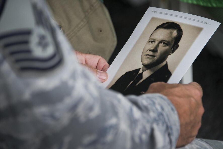 Airman holds old photo of .former commander.