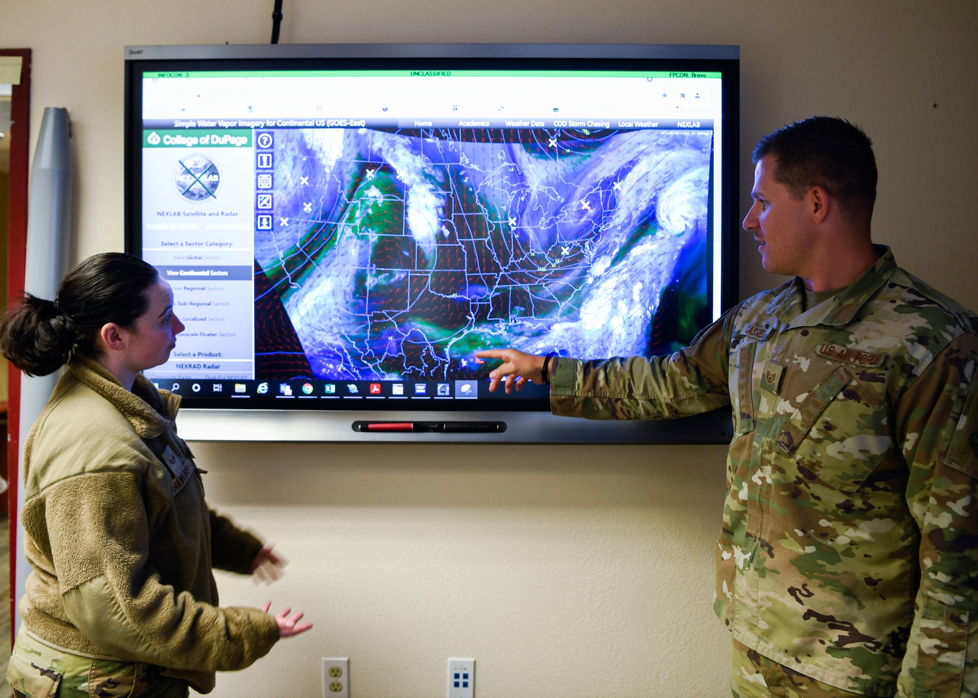 Staff Sgt. Craig Cassell, 56th Operations Support Squadron weather flight shift supervisor, and Senior Airman Breanna Hawkins, 56th OSS weather flight journeyman, observe weather patterns impacting the southwest United States June 15th, 2021, at Luke Air Force Base, Arizona.