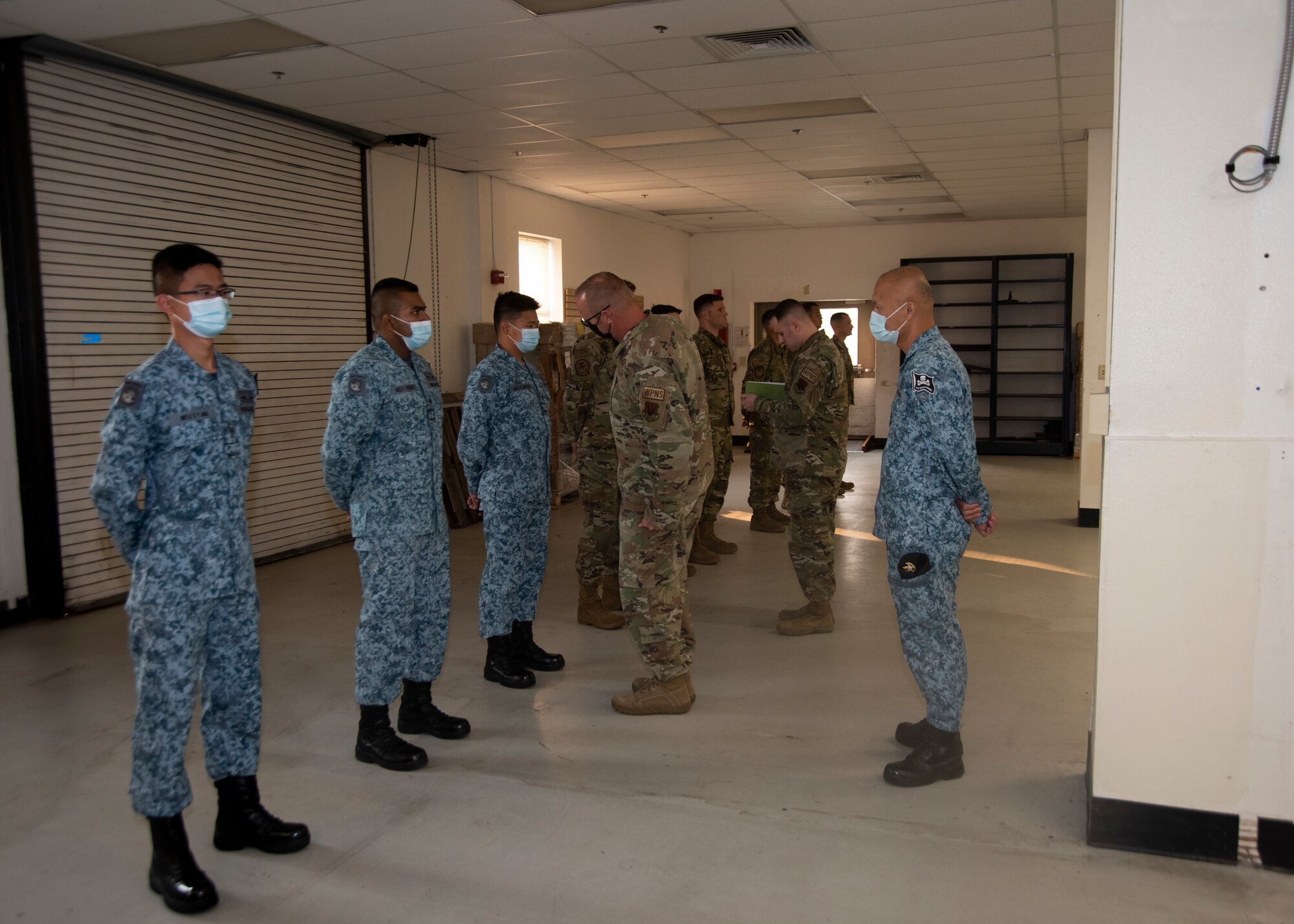 The Airmen from the United States Air Force and the Republic of Singapore Airmen get their uniforms inspected before the Quarterly Load Crew Competition begins.