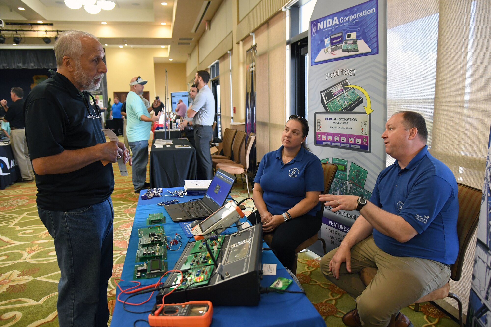Nida Corp. sales representatives explain training capabilities to Jerri Nappi, American Systems representative, during the Technology Expo inside the Bay Breeze Event Center at Keesler Air Force Base, Mississippi, July 15, 2021. The expo, hosted by the 81st Communications Squadron and AFCEA Gulf Coast Chapter, was held to introduce military members to the latest in technological advancements to bolster the Air Force's capabilities in national defense. (U.S. Air Force photo by Kemberly Groue)